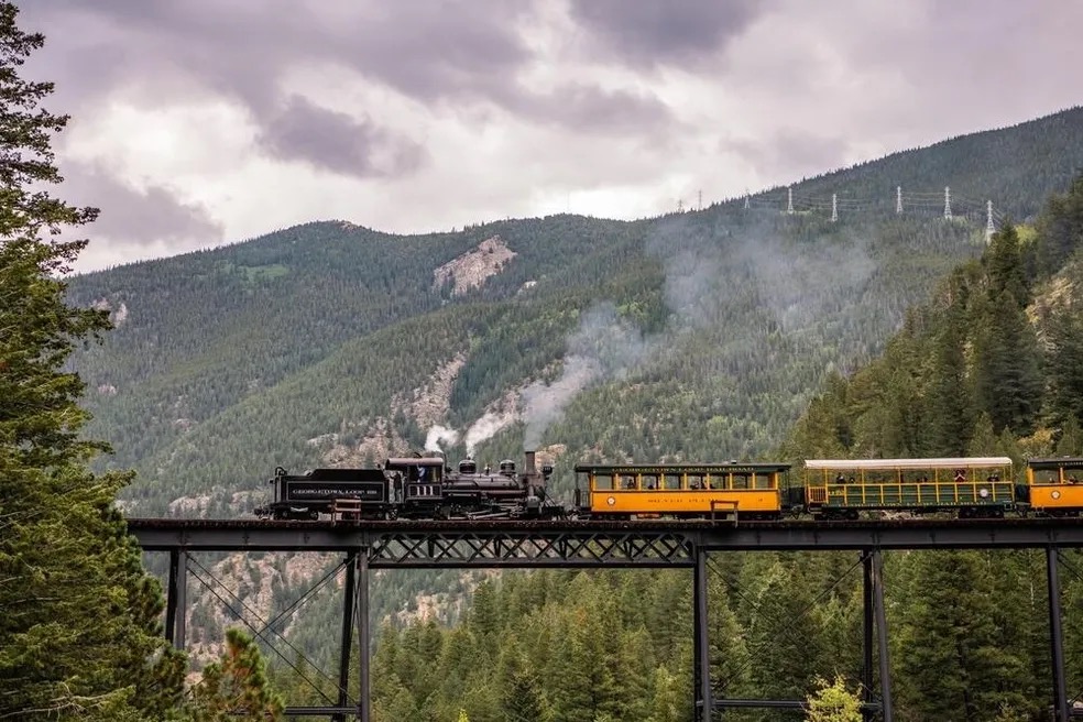 Skunk Train crossing a forested mountain bridge